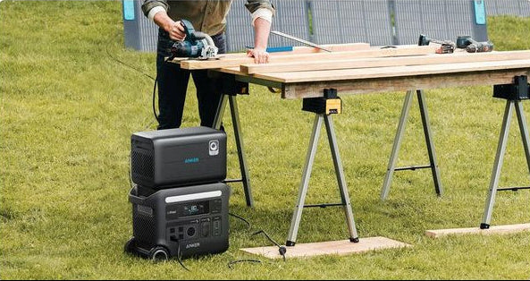 Anker BP2600 Portable Power Expansion Battery stacked on a power station, powering a circular saw on a wooden workbench
