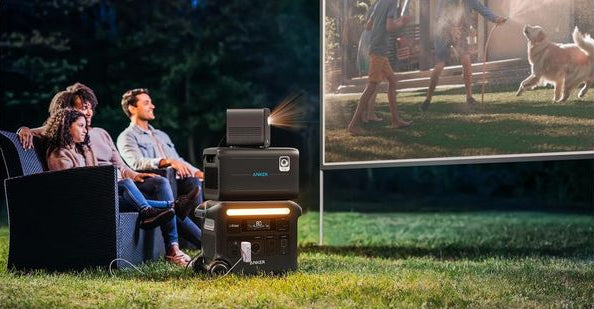 Anker BP2600 portable power expansion battery powering an outdoor projector during a backyard movie night.