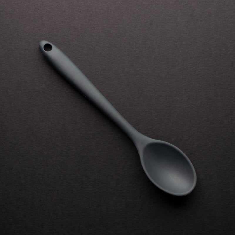 Graphite-colored 21cm mini silicone spoon with a hole at the handle end on a dark background