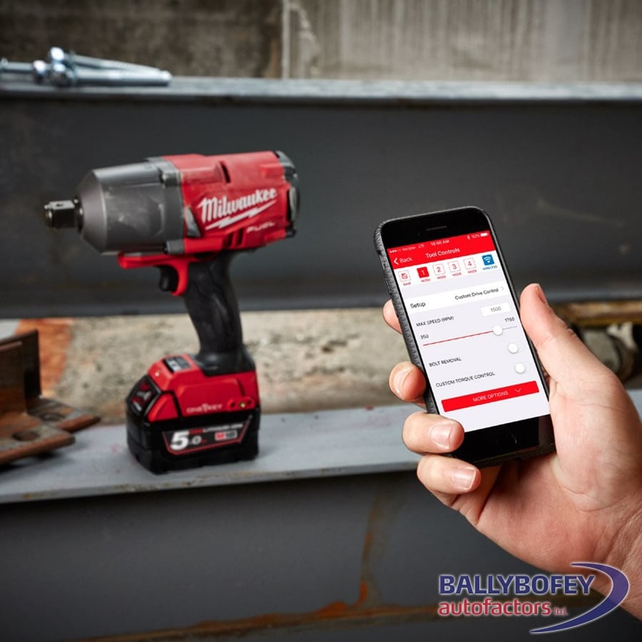 Milwaukee M18 Fuel High Torque Impact Wrench with 5.0 Ah battery next to hand holding phone showing tool control app.