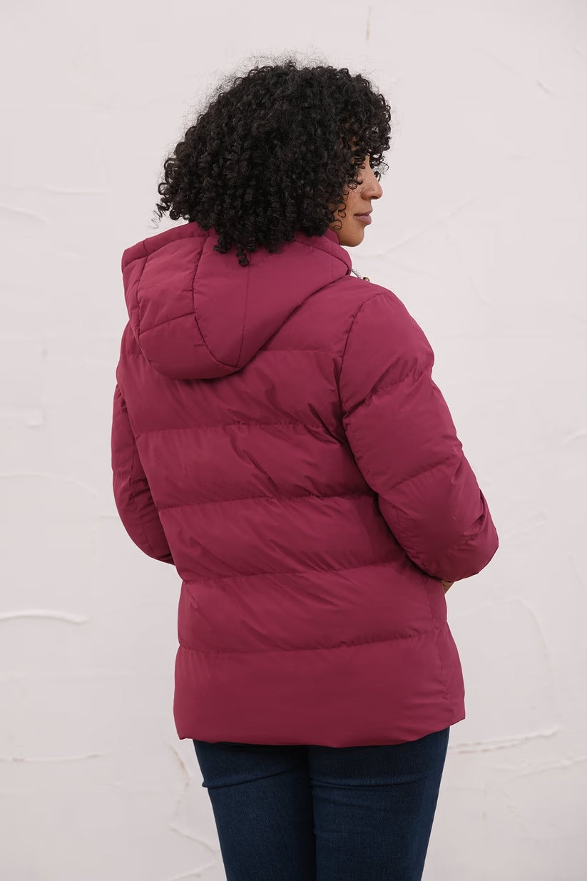 Back view of a woman wearing a berry-colored Margot Ladies Coat with a hood and horizontal quilting.