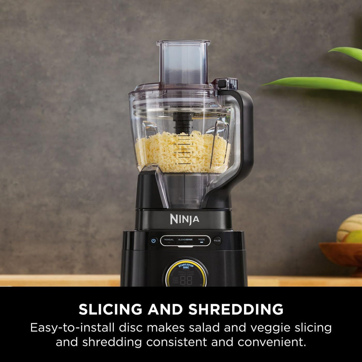 Ninja Detect Power Blender & Processor Pro with shredded cheese inside clear container on black base