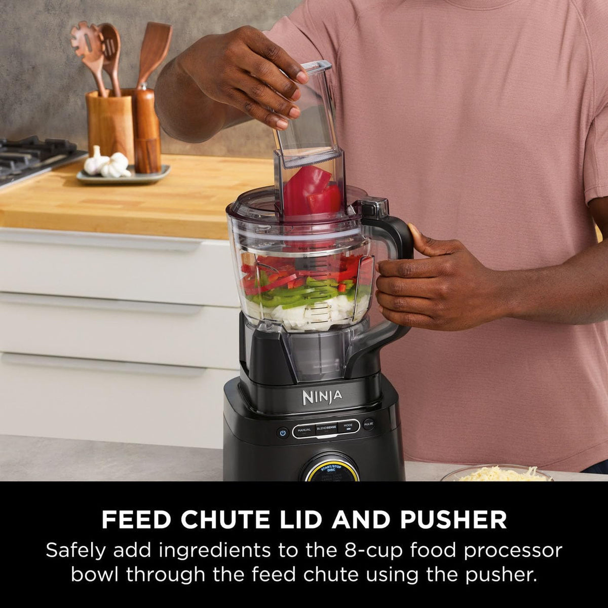 Person adding red bell pepper pieces into the Ninja Detect Power Blender & Processor Pro feed chute.