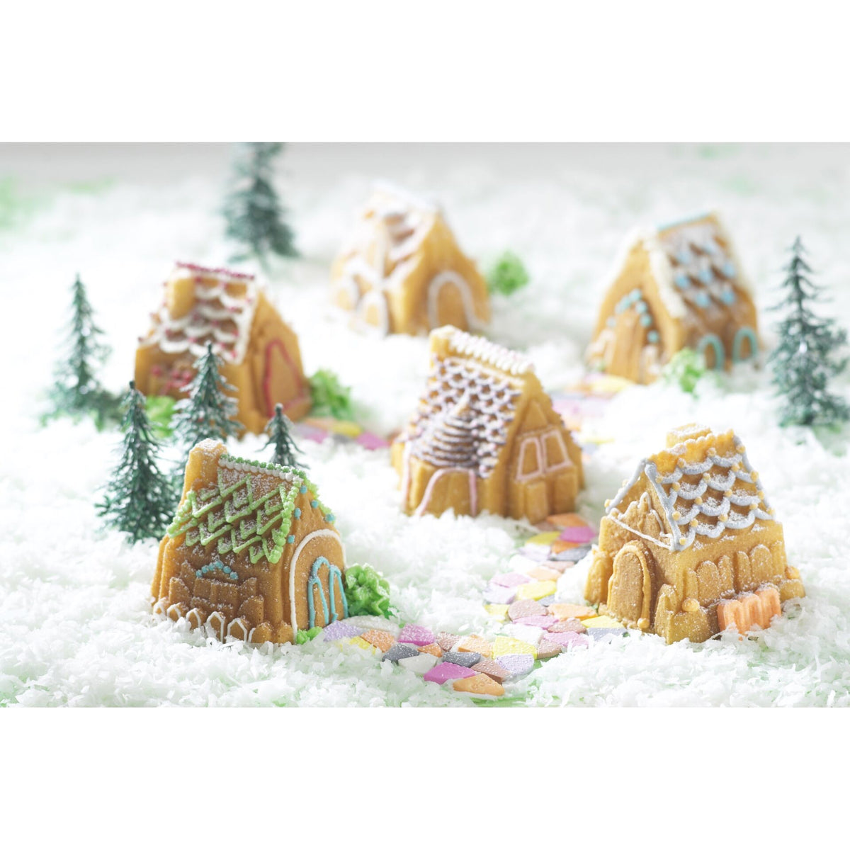 Silvery Cozy Village Bundt Pan showing a detailed winter village scene with decorated gingerbread houses and trees