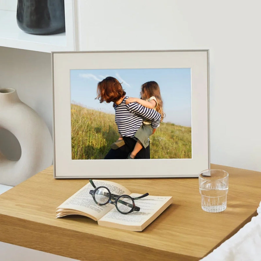Aura Walden 15 Inch Digital Photo Frame in clay with paper mat showing a woman carrying a child outdoors