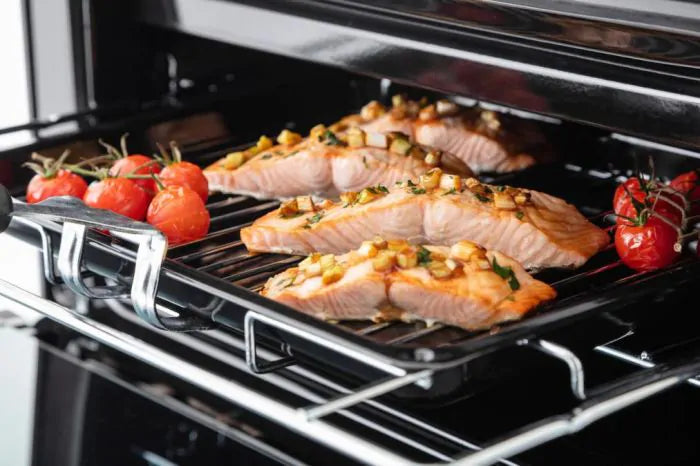 Rangemaster PROPL60ECSS/C stainless steel ceramic cooker oven interior with salmon and cherry tomatoes cooking