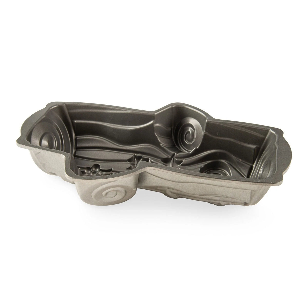 Silver Yule Log Pan with detailed swirls and holly leaf design inside, angled view on white background.