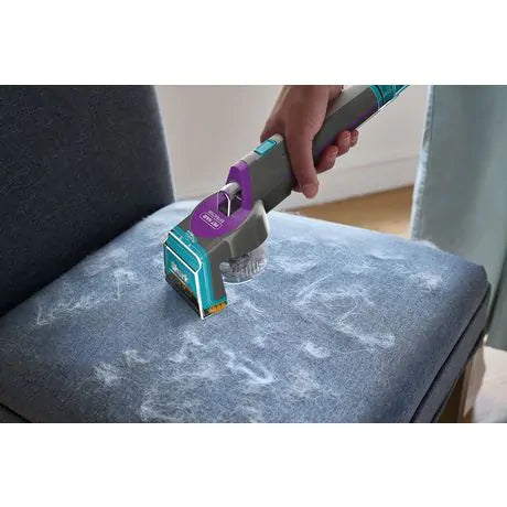 Shark Carpet Xpert PET PRO removing pet hair from a blue upholstered chair cushion.