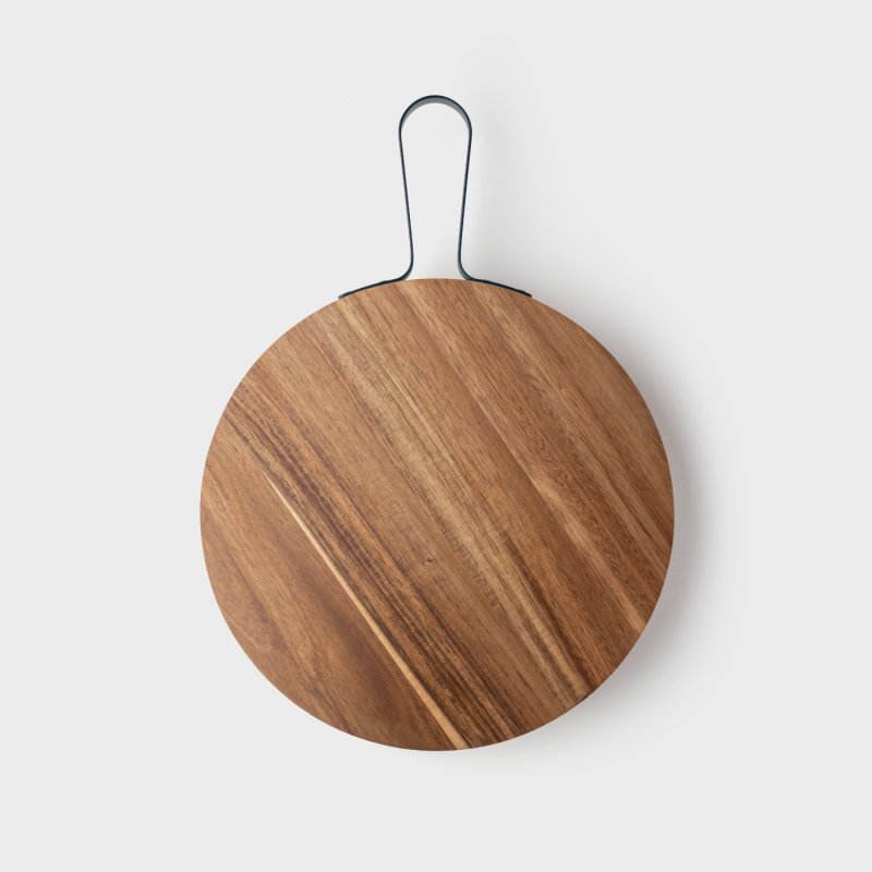 Round acacia wood charcuterie board with a black metal handle on a white background.