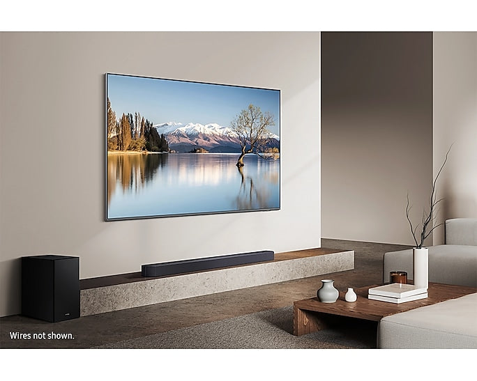 Samsung Q600F soundbar and subwoofer below wall-mounted TV in modern living room setting