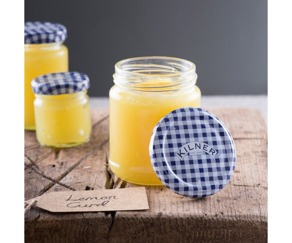 Kilner Round Twist Top Jar 370ml filled with lemon curd, lid resting beside on wooden surface