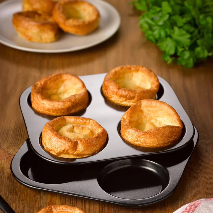 Tala Eclipse Yorkshire Pudding Tin with four golden baked puddings on a wooden surface
